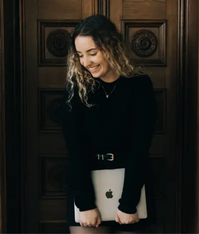 Aline Santana sorrindo, segurando um notebook